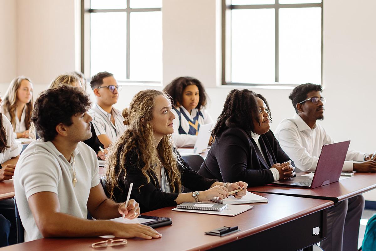 a group of students sitting in a classroom listening to a lecture